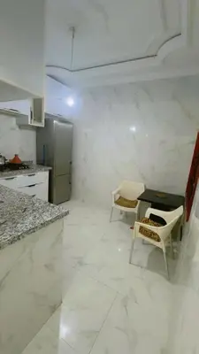 a kitchen with a table and chairs and a refrigerator at Chic & Cozy Apartment in Marrakech