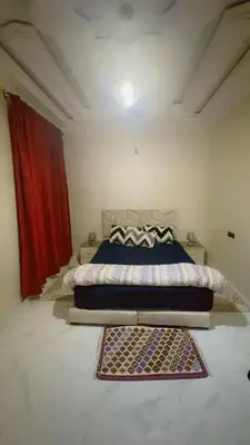 a bedroom with a bed and a red curtain at Chic & Cozy Apartment in Marrakech
