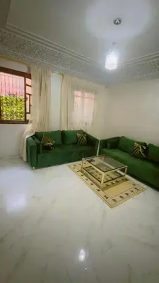 a living room with a green couch and a table at Chic & Cozy Apartment in Marrakech