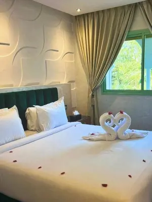 two swans towels on a bed in a bedroom at Stylish Retreat in Marrakech