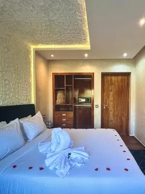 a bedroom with a large white bed with roses on it at Stylish Retreat in Marrakech