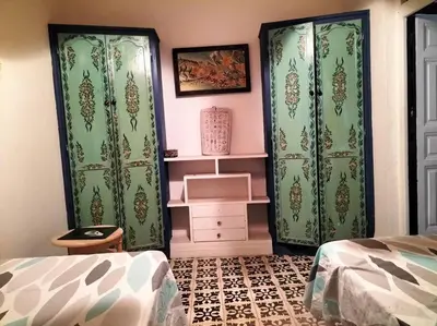 a bedroom with two green curtains and a bed at Dar tranquille in Marrakech