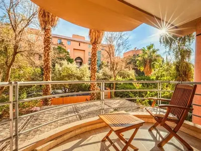a patio with a table and a chair on a balcony at Timeless Hideaway in Marrakech