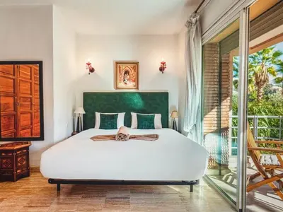 a bedroom with a large white bed and a balcony at Timeless Hideaway in Marrakech