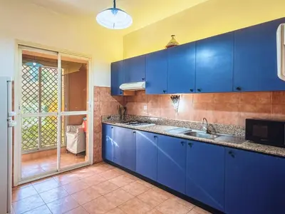 a blue kitchen with a sink and a window at Timeless Hideaway in Marrakech