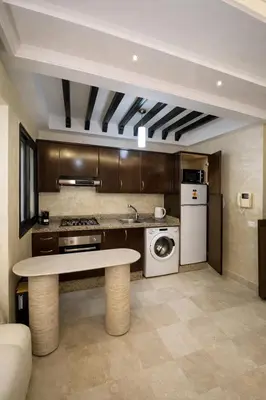 a kitchen with a table and a washer and dryer at Spacious studio with pool Guéliz in Marrakech