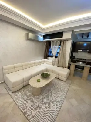a living room with a white couch and a coffee table at Spacious studio with pool Guéliz in Marrakech