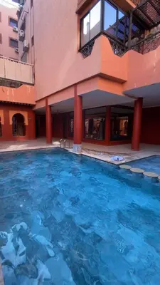 a large swimming pool in front of a building at Spacious studio with pool Guéliz in Marrakech