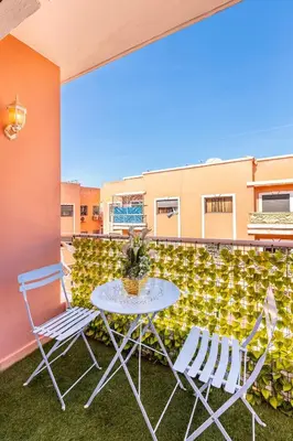 a patio with a table and chairs on a balcony at Appartement spacieux 83 m carré Wi Fi Marrakech in Marrakech