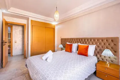 a bedroom with a large bed with orange and white pillows at Appartement spacieux 83 m carré Wi Fi Marrakech in Marrakech