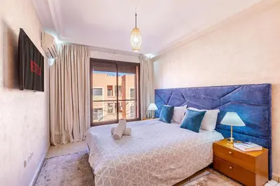 a bedroom with a large bed and a large window at Appartement spacieux 83 m carré Wi Fi Marrakech in Marrakech