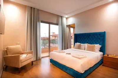 a bedroom with a blue bed and a chair at Villa de luxe et plaisir in Marrakech