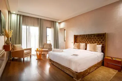 a hotel room with a large bed and a chair at Villa de luxe et plaisir in Marrakech
