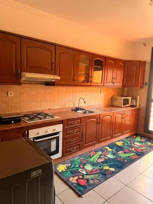 a kitchen with wooden cabinets and a rug on the floor at Tay Home in Marrakech