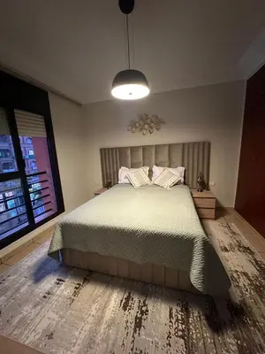 a bedroom with a bed and a large window at Tay Home in Marrakech