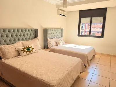 a bedroom with two beds and a window at Tay Home in Marrakech