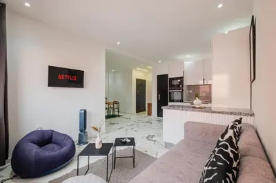 a living room with a couch and a kitchen at Modern & Cozy Apartment 2 min Carré Eden Guéliz in Marrakech