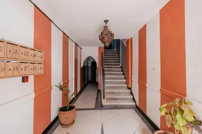 a hallway with orange and white walls and stairs at Modern & Cozy Apartment 2 min Carré Eden Guéliz in Marrakech