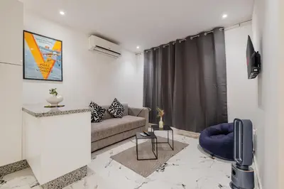 a living room with a couch and a tv at Modern & Cozy Apartment 2 min Carré Eden Guéliz in Marrakech