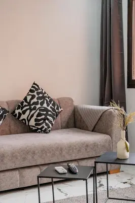 a living room with a couch and two tables at Modern & Cozy Apartment 2 min Carré Eden Guéliz in Marrakech