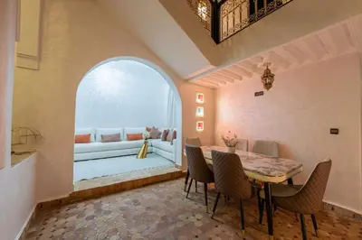 a dining room with a table and chairs and a couch at Riad Marrakech 4-bedroom Riad in the heart of Marrakesh with Pool in Marrakech