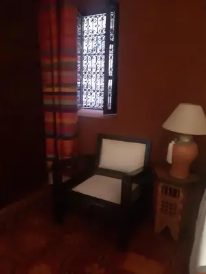 a chair and a lamp in a room with a window at Riad ICA in Marrakech