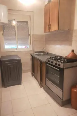 a kitchen with a stove and a sink at appartement pour famille ou femme in Marrakech