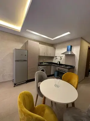 a kitchen with a white table and chairs and a table and a counter at Guéliz 5 min away - Quiet - Pool & Parking in Marrakech