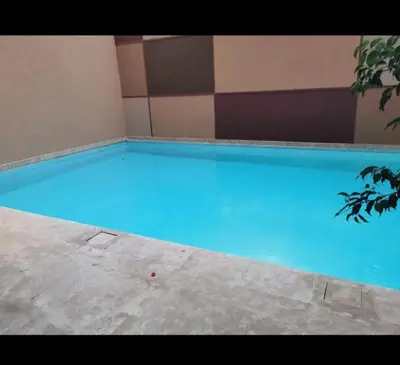 a large blue swimming pool in a building at Guéliz 5 min away - Quiet - Pool & Parking in Marrakech