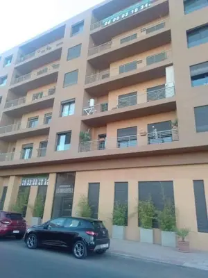 a black car parked in front of a large building at Guéliz 5 min away - Quiet - Pool & Parking in Marrakech