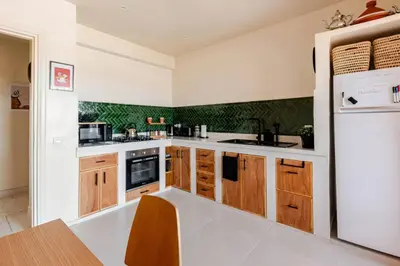 a kitchen with wooden cabinets and a refrigerator at 3 chambres lumineux au centre de Marrakech in Marrakech