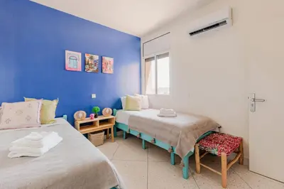 a room with two beds and a blue wall at 3 chambres lumineux au centre de Marrakech in Marrakech