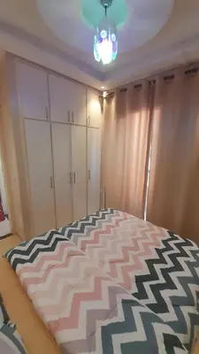 a bedroom with a large bed with a black and white blanket at Pied-à-terre Calme & Climatisé à 5 min du Centre in Marrakech
