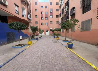 an empty street with potted trees and buildings at Pied-à-terre Calme & Climatisé à 5 min du Centre in Marrakech
