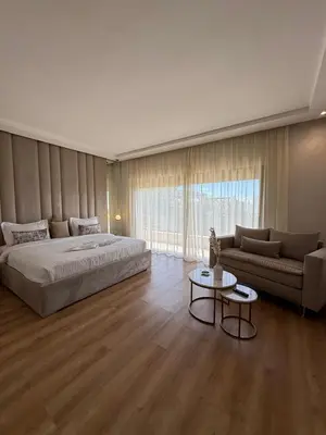 a bedroom with a bed and a couch and a table at Villa 60 Saphir in Marrakech