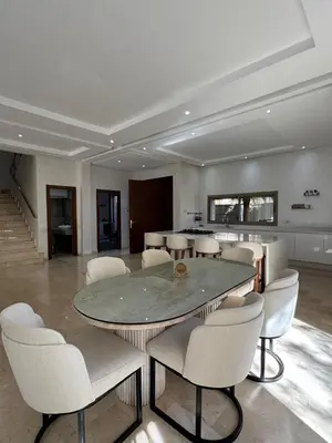 a dining room with a table and white chairs at Villa 60 Saphir in Marrakech
