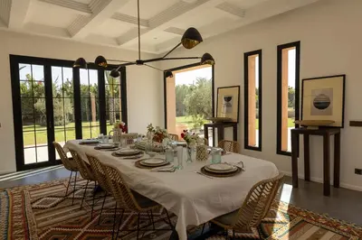 a dining room with a long table and chairs at Villa Yemna - Villa signature Paddle Marrakech in Segraga