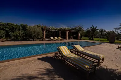 two lounge chairs next to a swimming pool at Villa Yemna - Villa signature Paddle Marrakech in Segraga