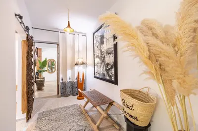 a hallway with a wicker chair and aumedumed feather wall at Riad Kenous - Exclusive&New -6 pax- Pool & Breakfast in Marrakech