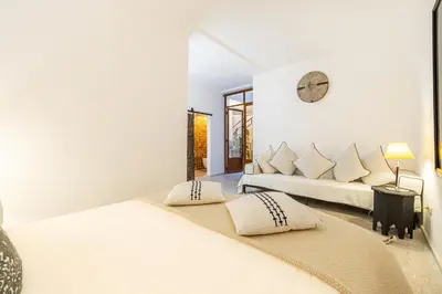 two beds in a bedroom with a clock on the wall at Riad Kenous - Exclusive&New -6 pax- Pool & Breakfast in Marrakech