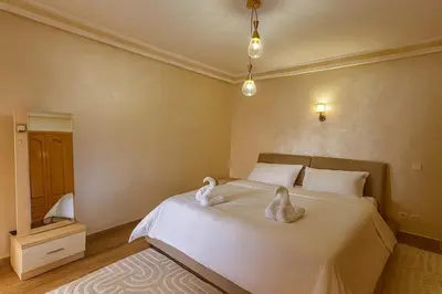 two swans sitting on a bed in a bedroom at Marrakech Cozy Family Home piscine et wifi in Marrakech