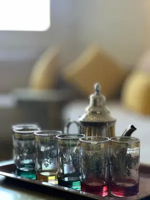 a tray with four glasses and a tea kettle at Marrakech Cozy Family Home piscine et wifi in Marrakech
