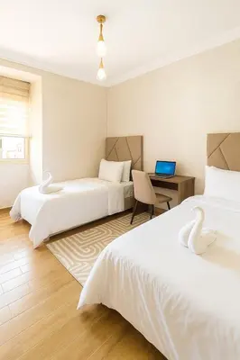 a room with two beds and a desk with a laptop at Marrakech Cozy Family Home piscine et wifi in Marrakech