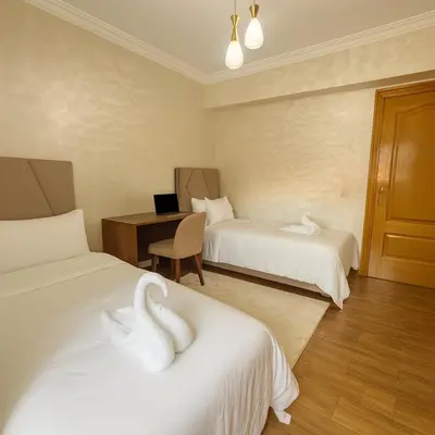 a hotel room with two swans on the beds at Marrakech Cozy Family Home piscine et wifi in Marrakech