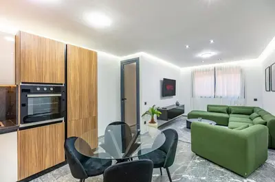 a living room with a green couch and a glass table at Modern apartment, design and cozy relaxing stay in Marrakech