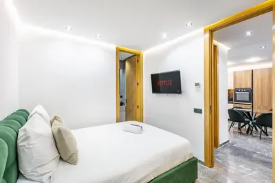 a bedroom with a bed and a tv on the wall at Modern apartment, design and cozy relaxing stay in Marrakech