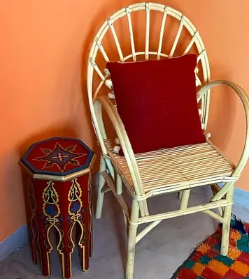 a chair with a red pillow next to a stool at Riad Green Atlas in Marrakech
