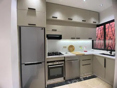 a kitchen with stainless steel appliances and white cabinets at appartment L'Hivernage in Marrakech