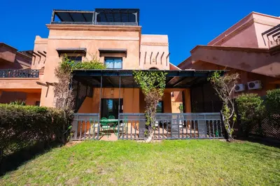 a house with a balcony in front of it at 1 Bedroom Apartment with Private Garden, Terrace and Pool in Marrakech