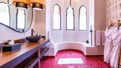 a bathroom with a tub and a sink and a mirror at Villa Rehame in Oulad Jellal